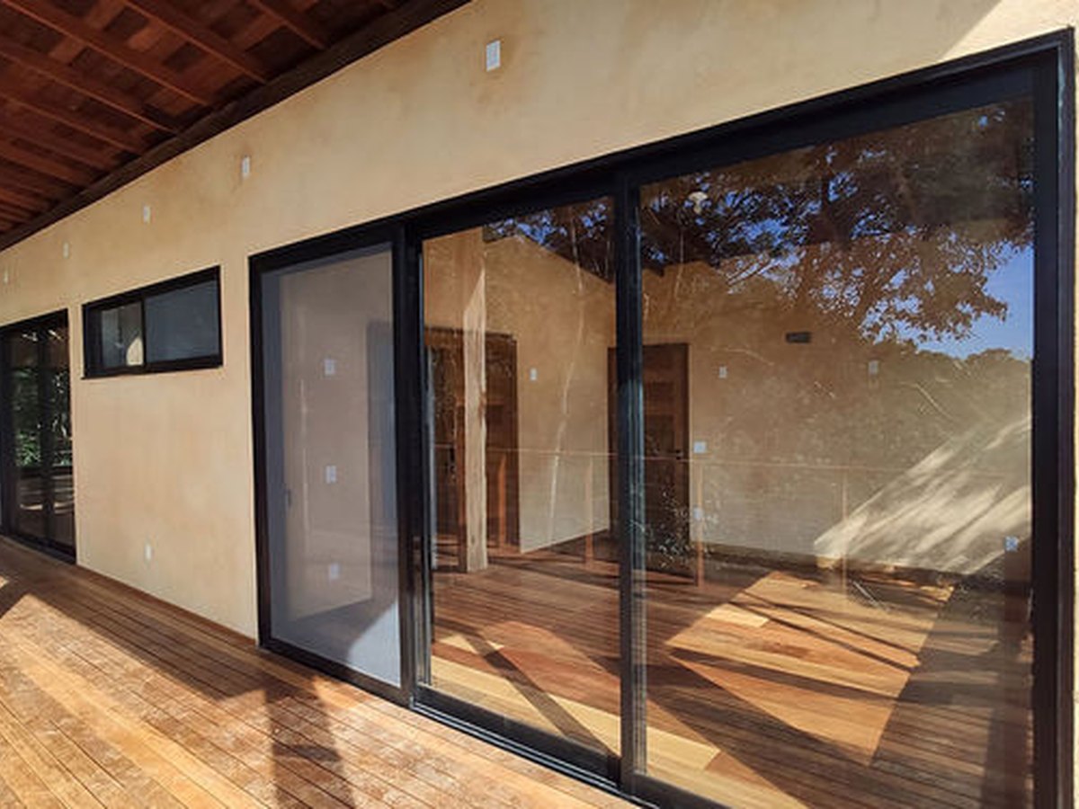 Portas de correr em alumínio preto abrindo para o deck